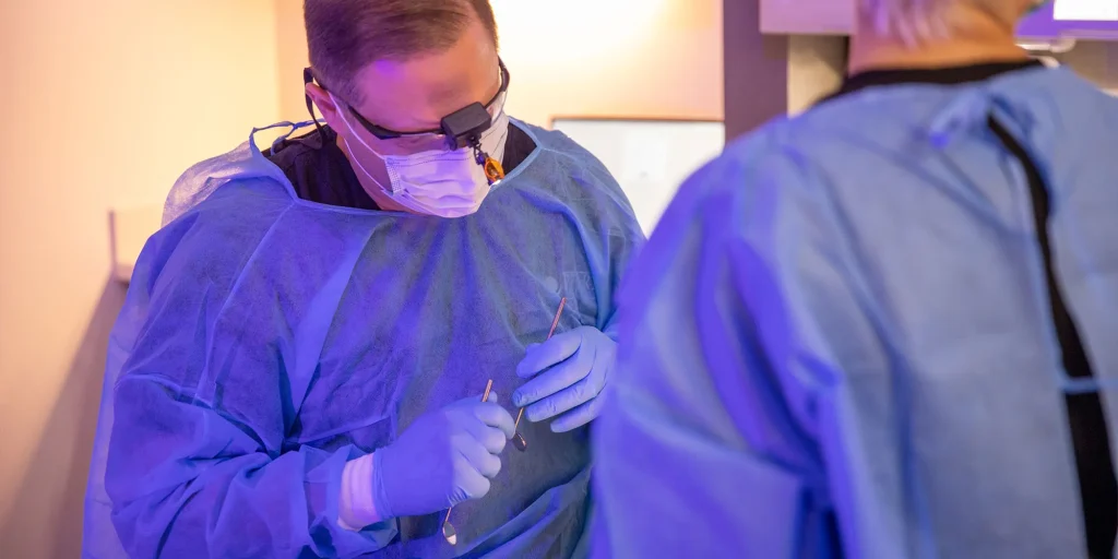 Dr. Andre’ Bruni performing dental implant surgery with a surgical assistant at Pearl Dental Group in Baton Rouge, LA.