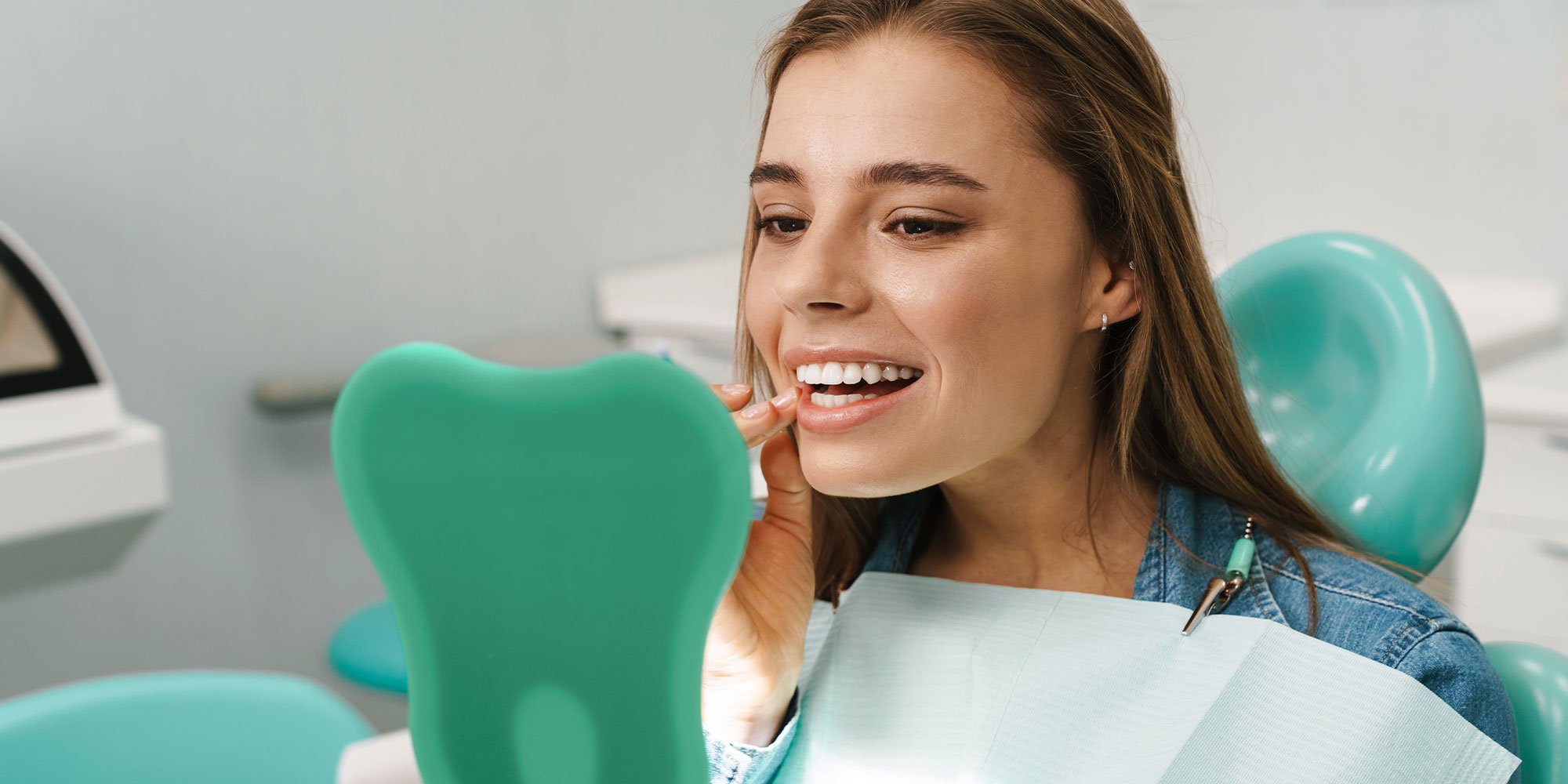 Woman placing a clear aligner at the dental office
